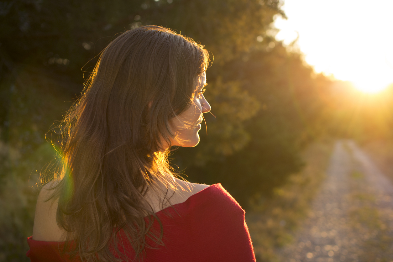 woman walking on a trail enjoying sunset