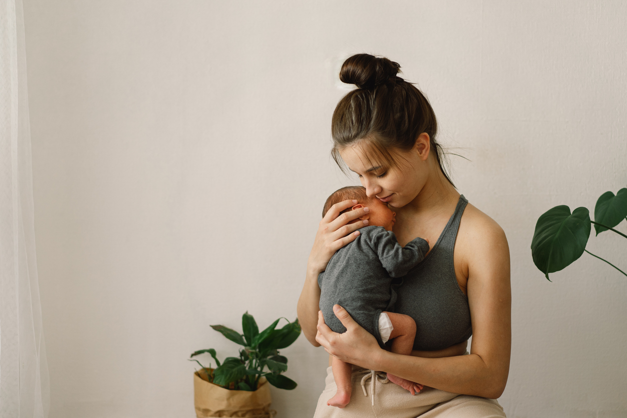 woman cuddling her newborn baby