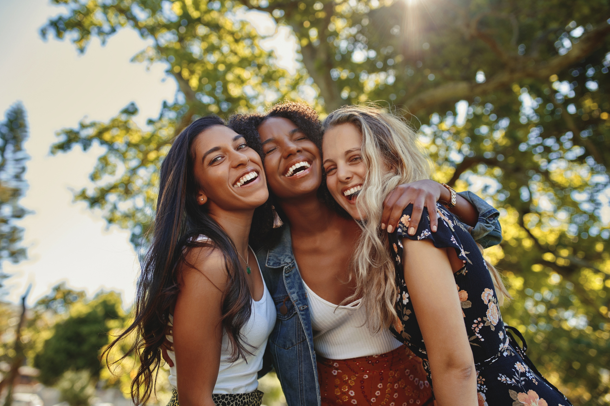 three girlfriends laughing outdoors