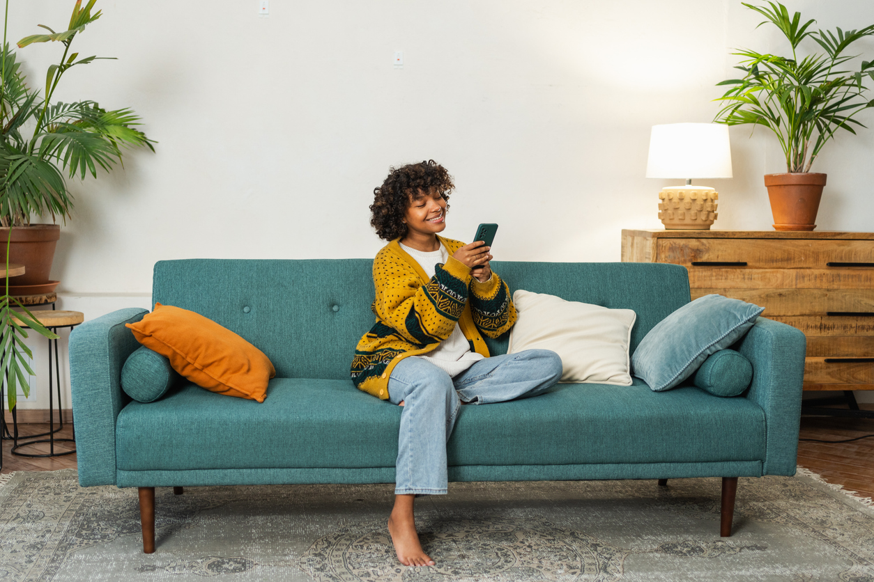 woman using a time management app while relaxing on the sofa