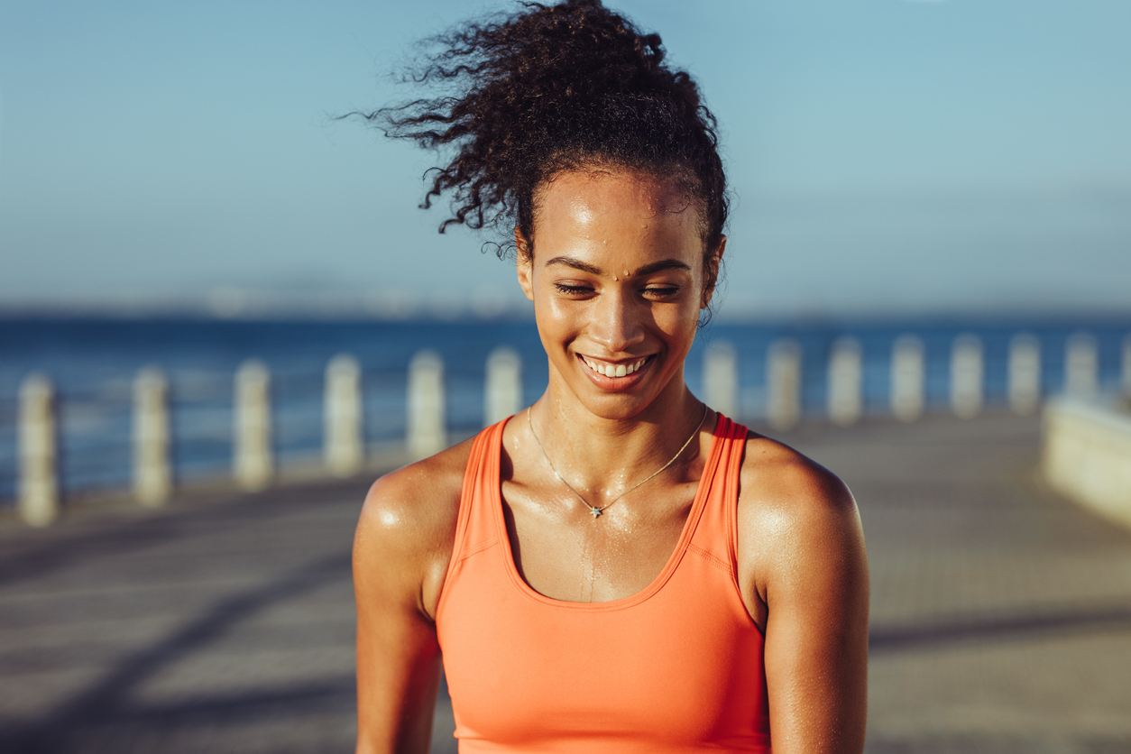 woman jogging and sweating near the ocean