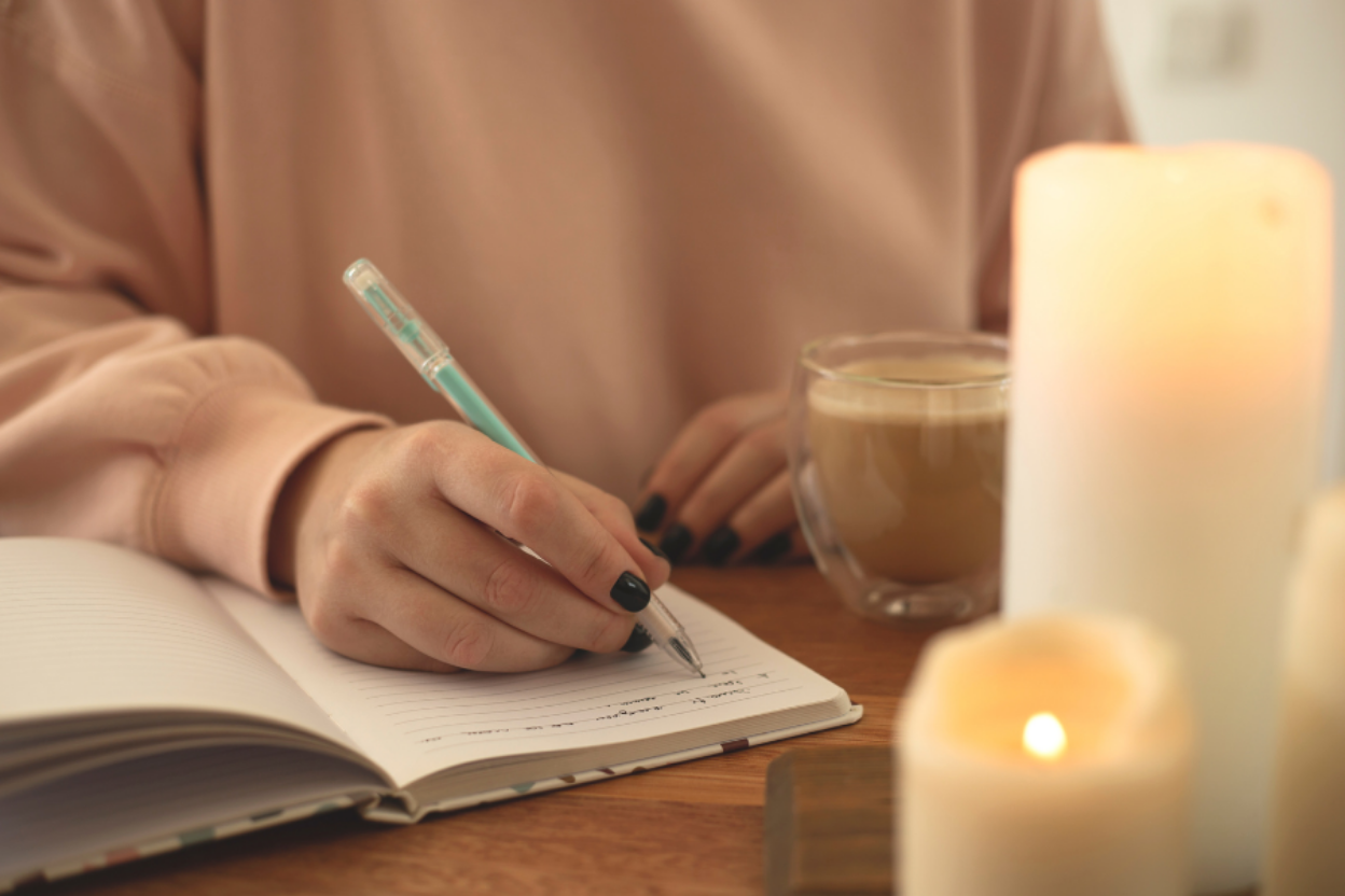 woman journaling while drinking coffee