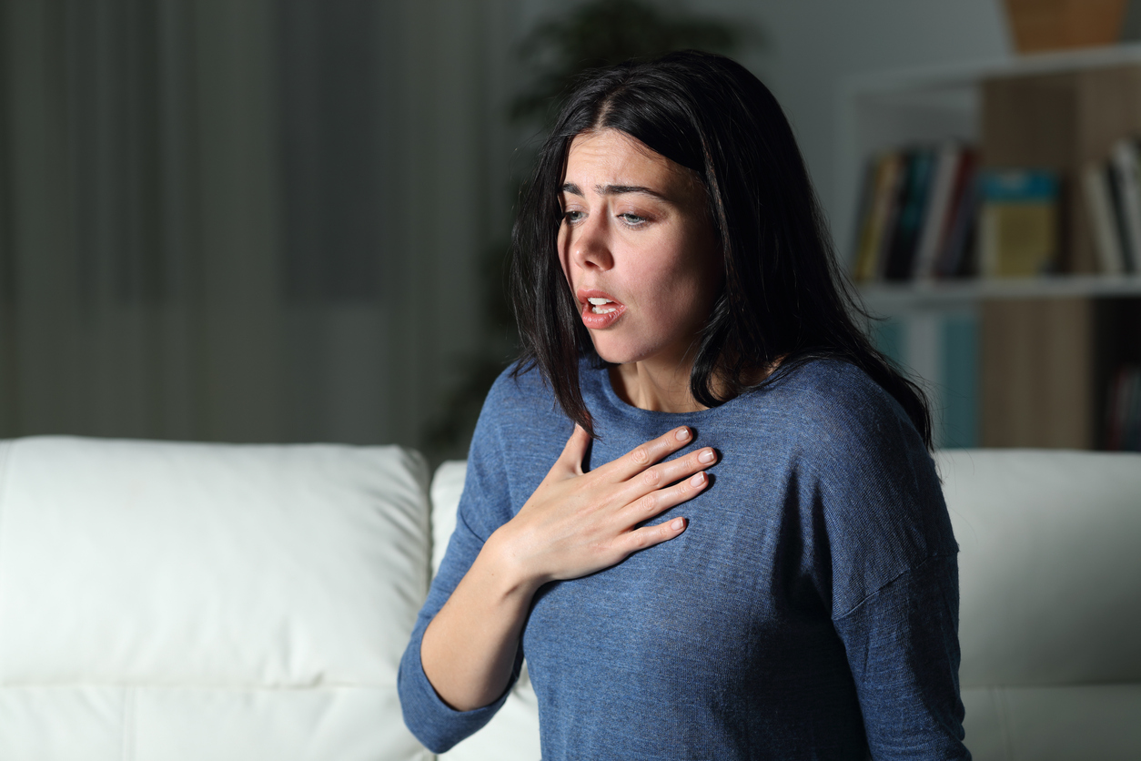 woman clutching her chest due to postpartum anxiety