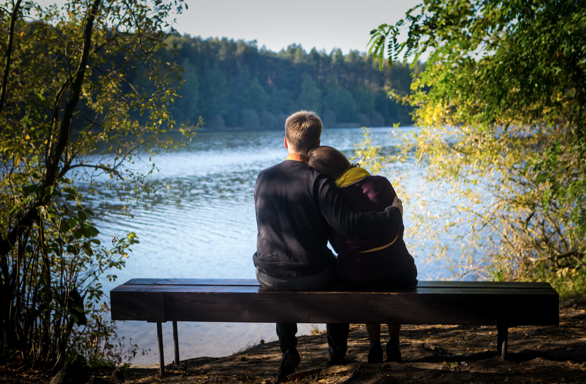 couple on a bench looking at a lake