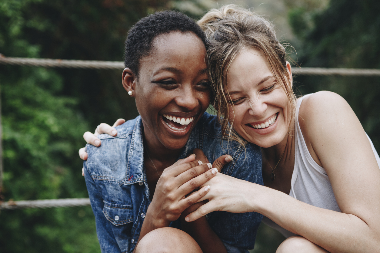 two women laughing and embracing