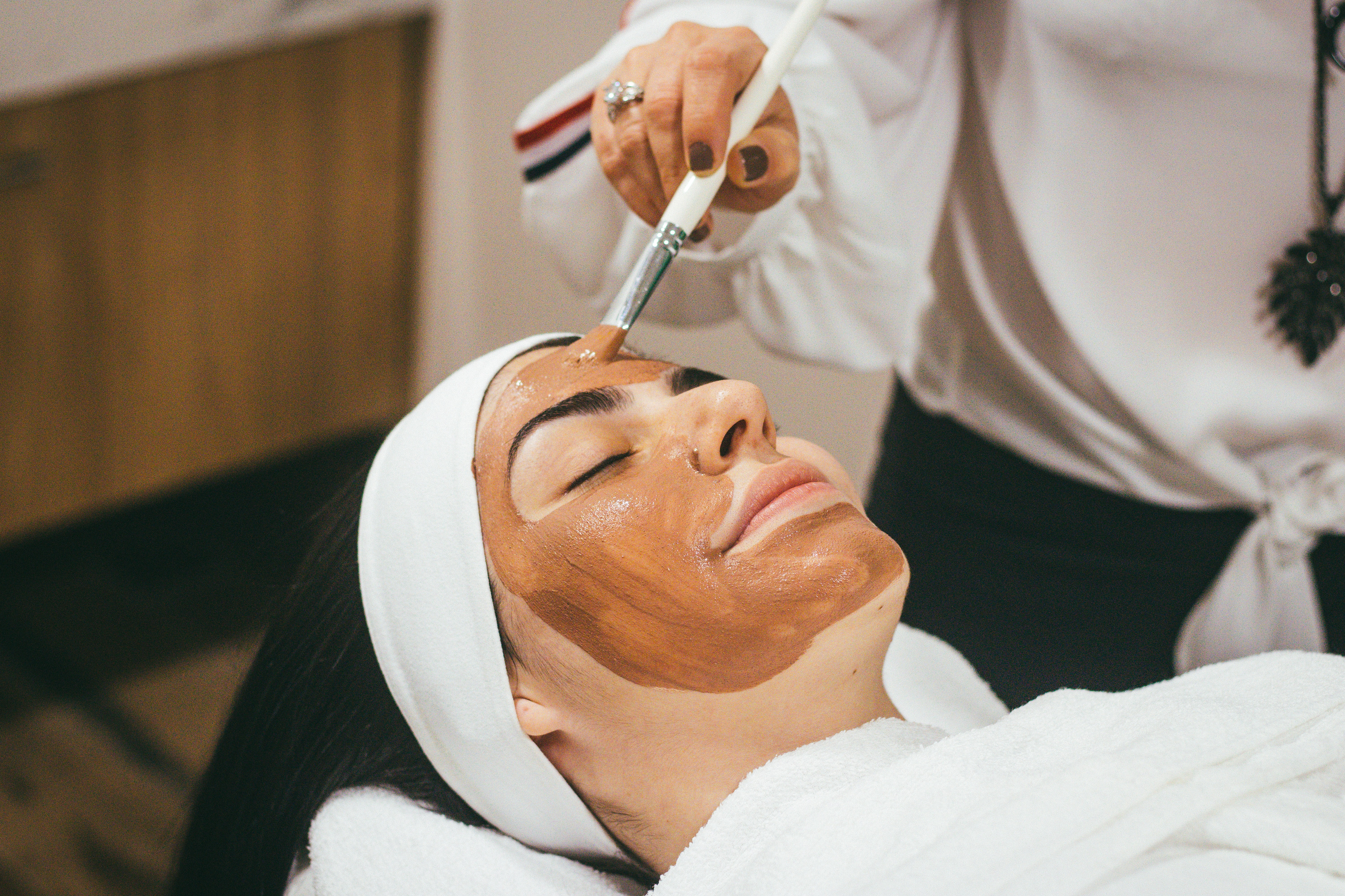 esthetician applying mask on a woman