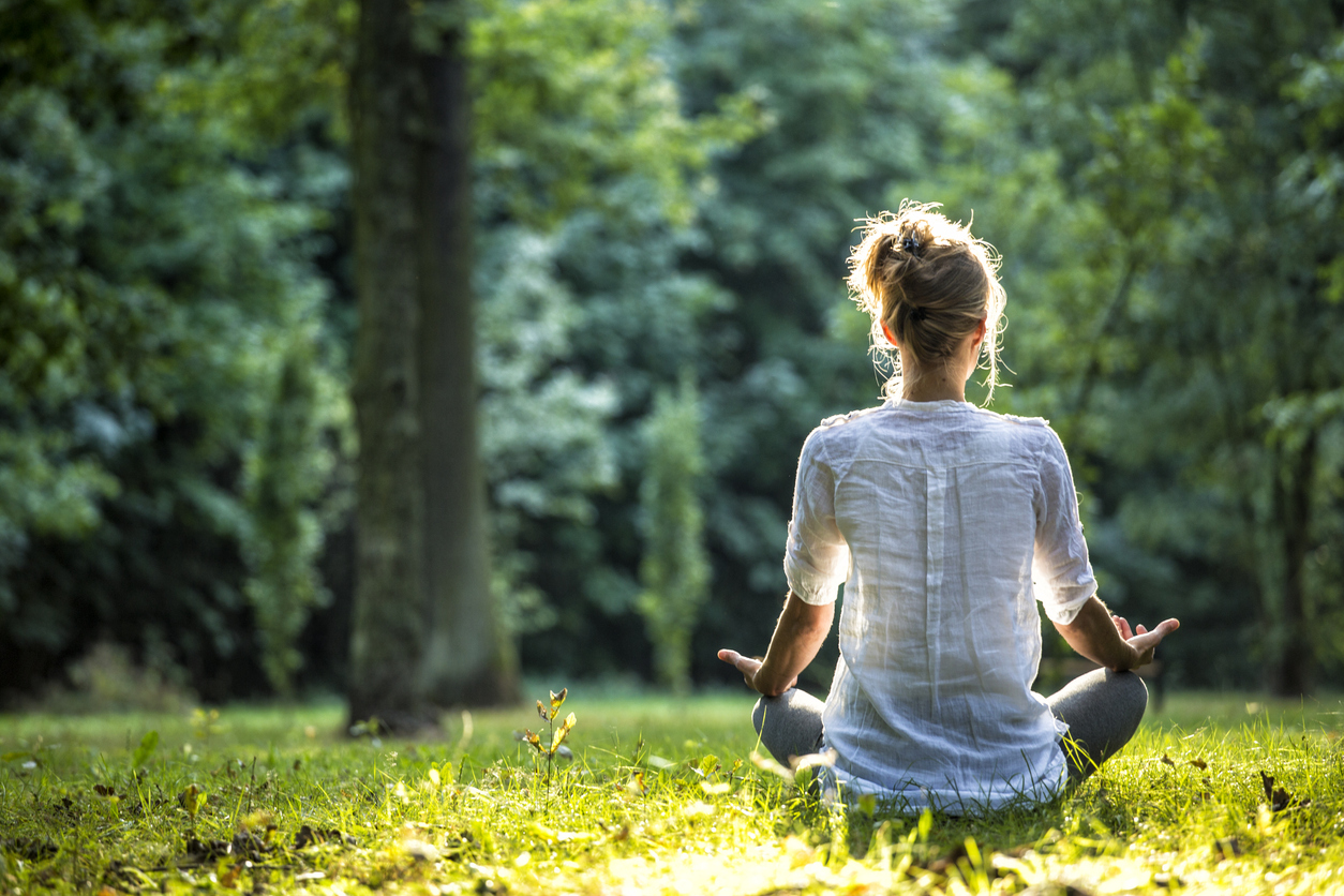 woman meditating in a field