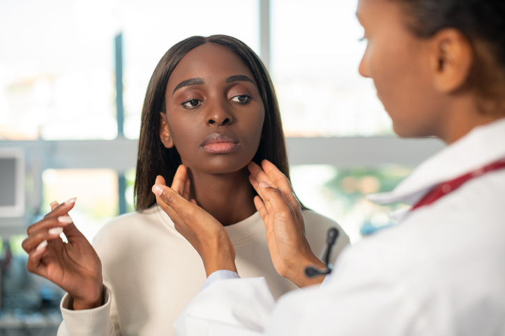 doctor examining a women's neck for thyroid issues