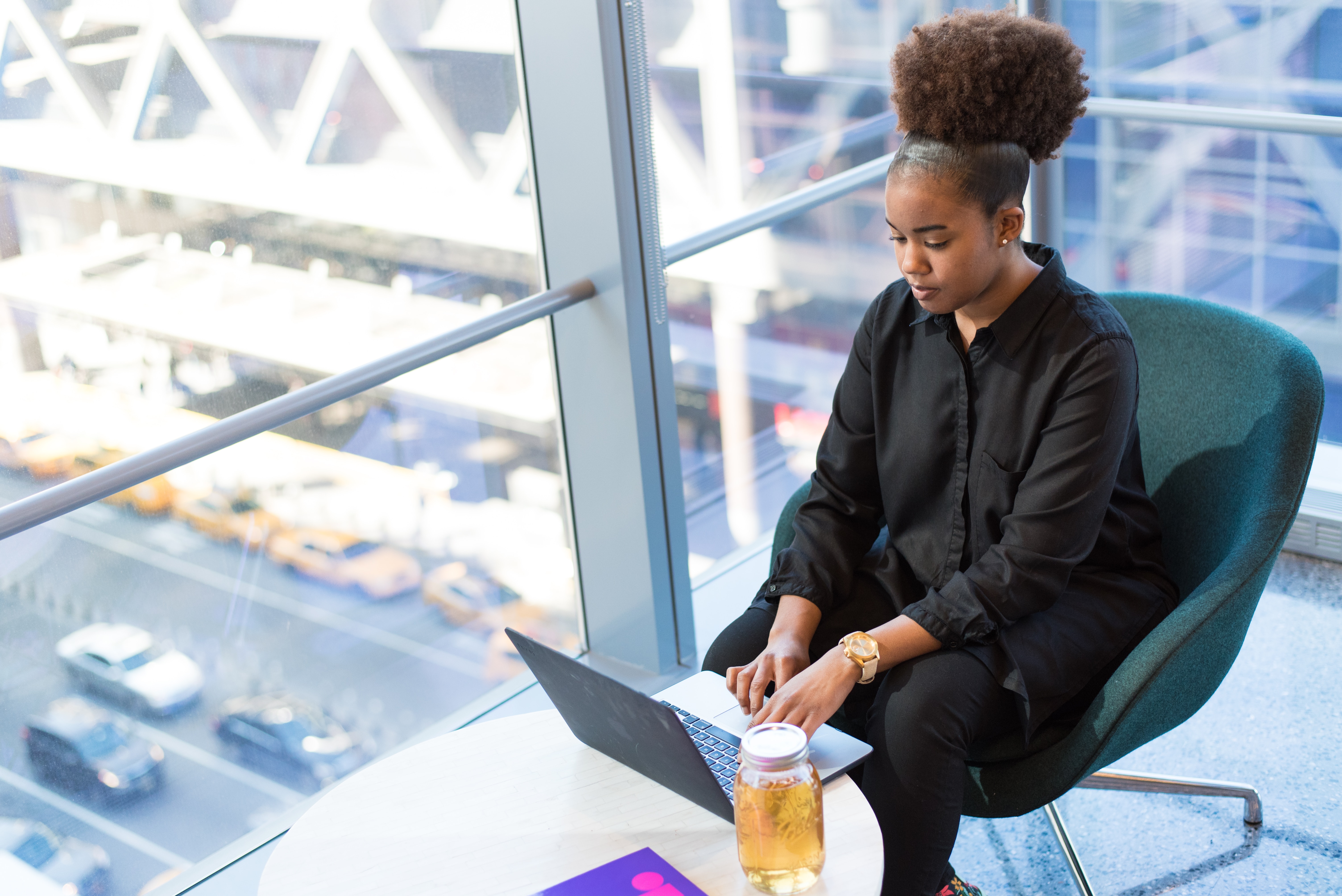 woman working on her laptop in a high rise office building