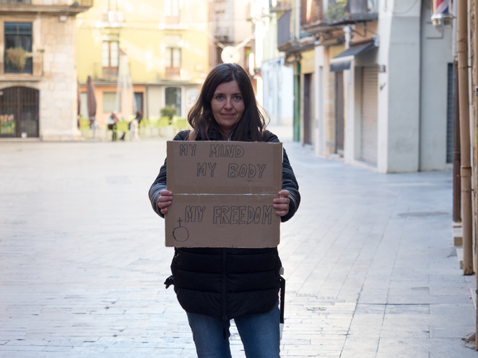 woman holding sign that reads "my mind, my body, my freedom"