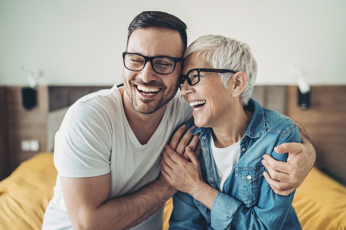 mother and son laughing and embracing on the sofa