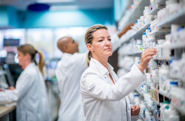 pharmacist stocking medicine on a shelf