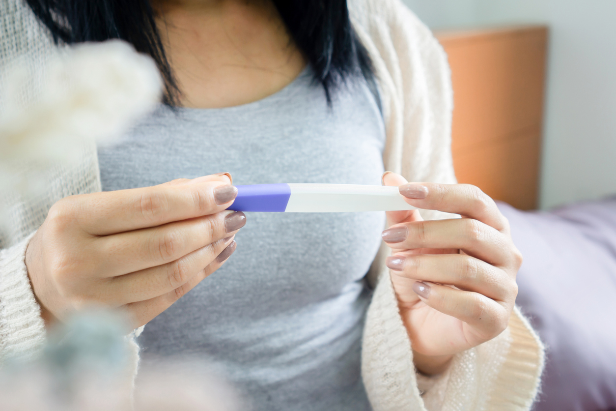 woman holding a pregnancy test