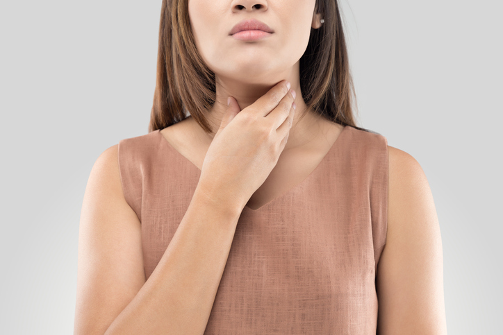 woman touching her thyroid