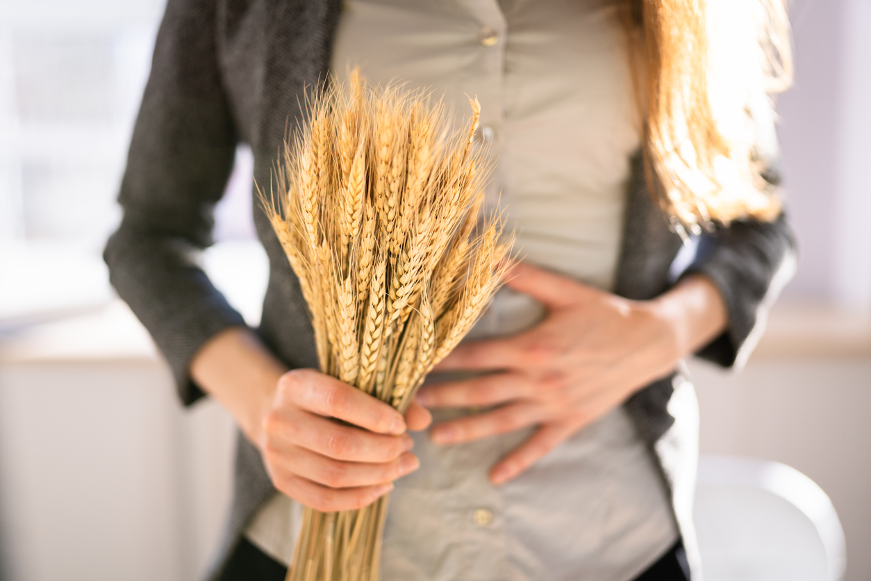 woman with gluten intolerance holding a bouquet of wheat