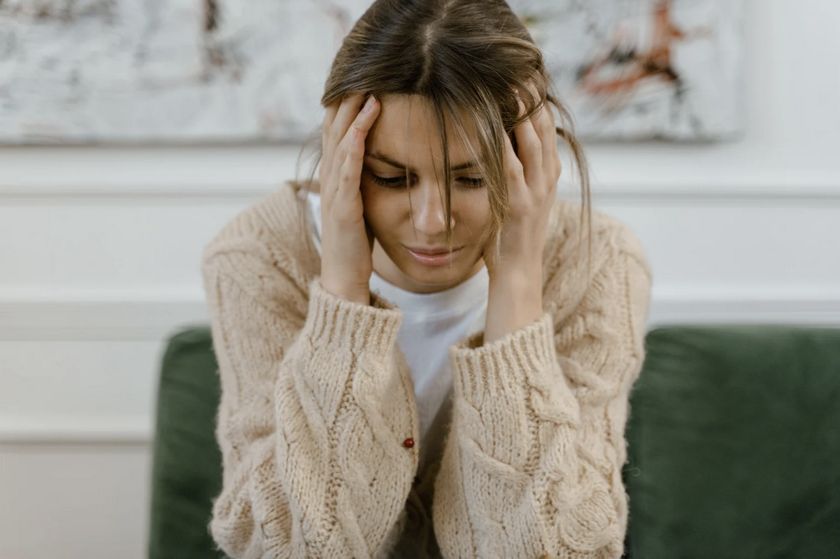 woman clutching in her head in distress