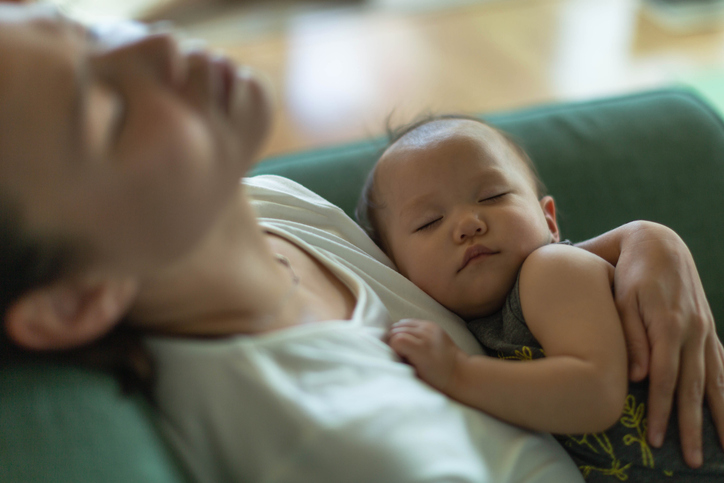 new mom asleep with sleeping baby in her arms