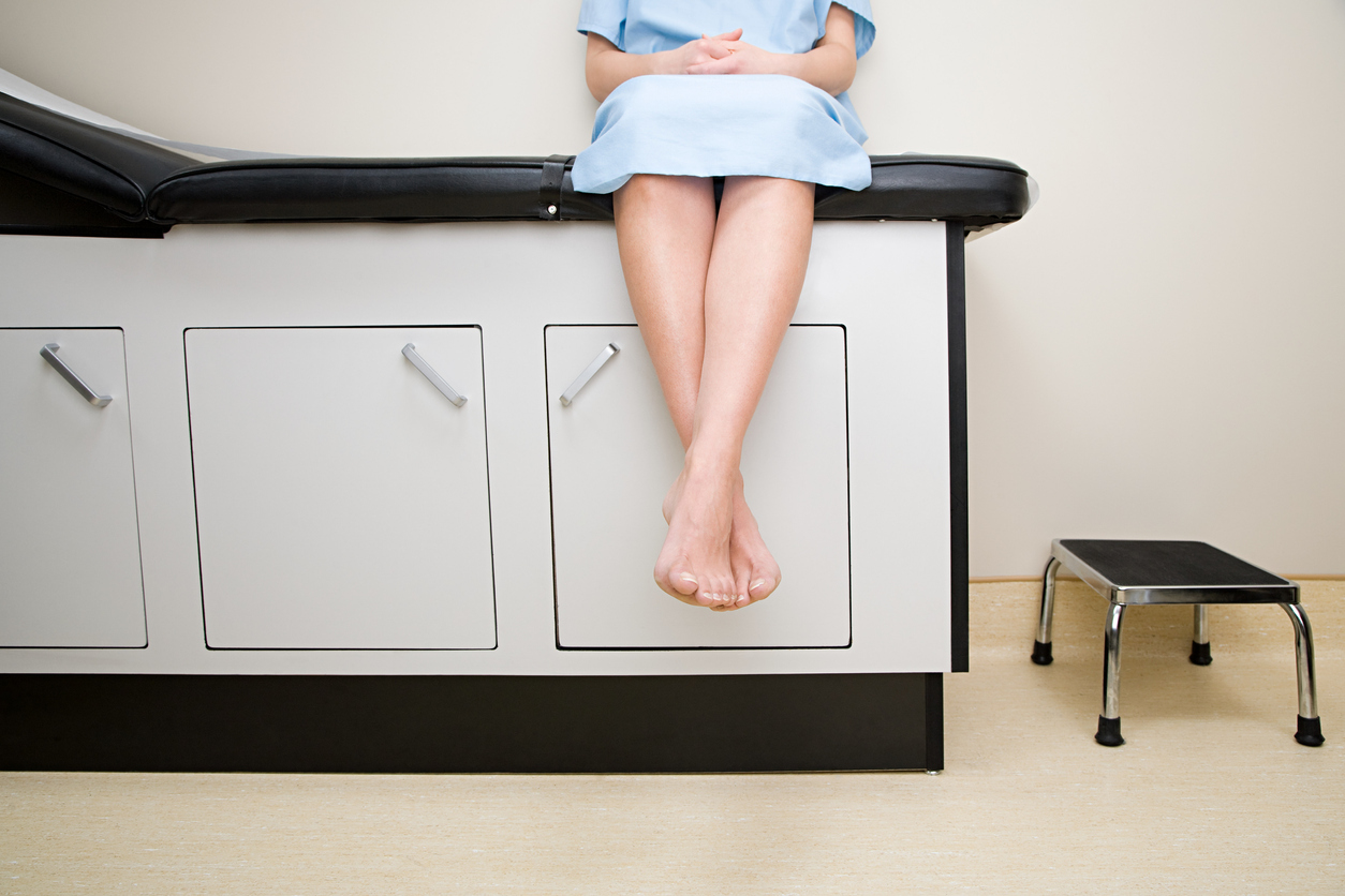 patient sitting on a counter in a medical office waiting for a leep procedure