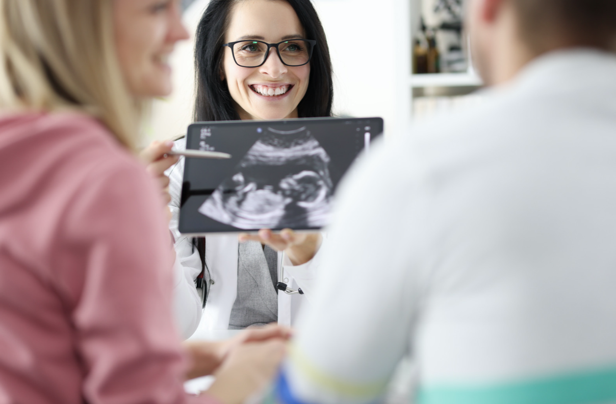 doctor showing couple an ultrasound image of their fetus