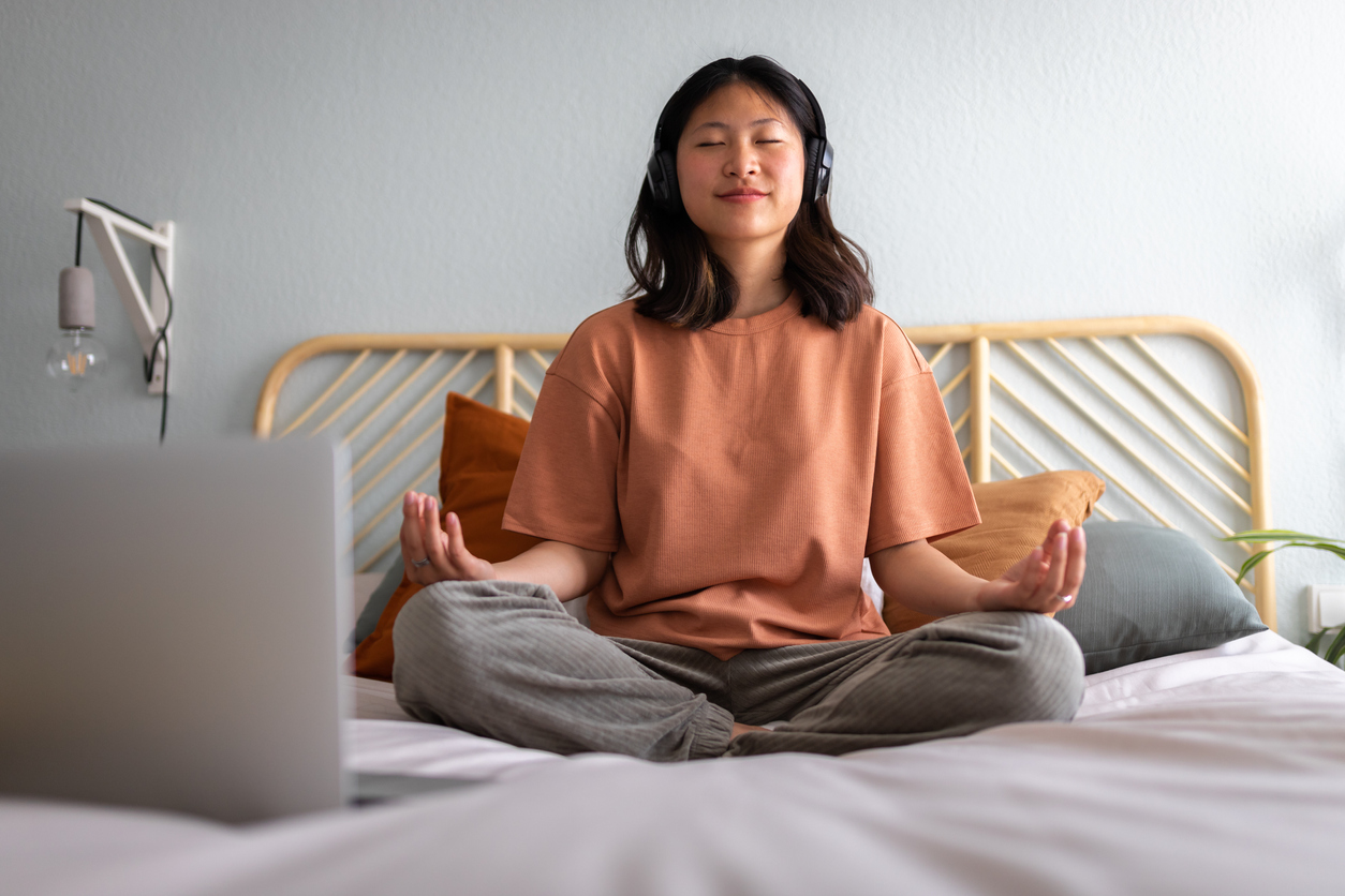 woman meditating on her bed