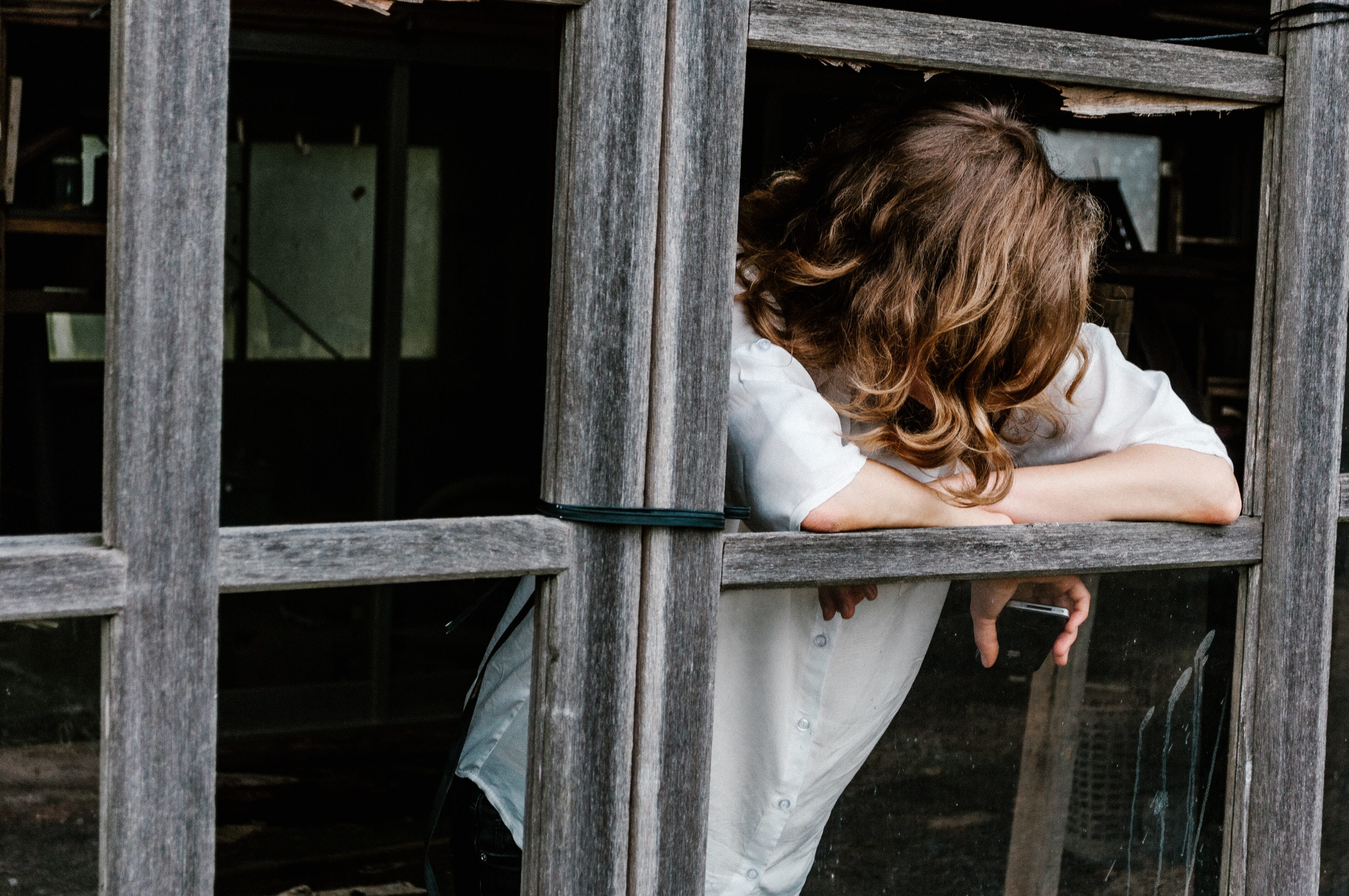 sad woman looking through wood framing