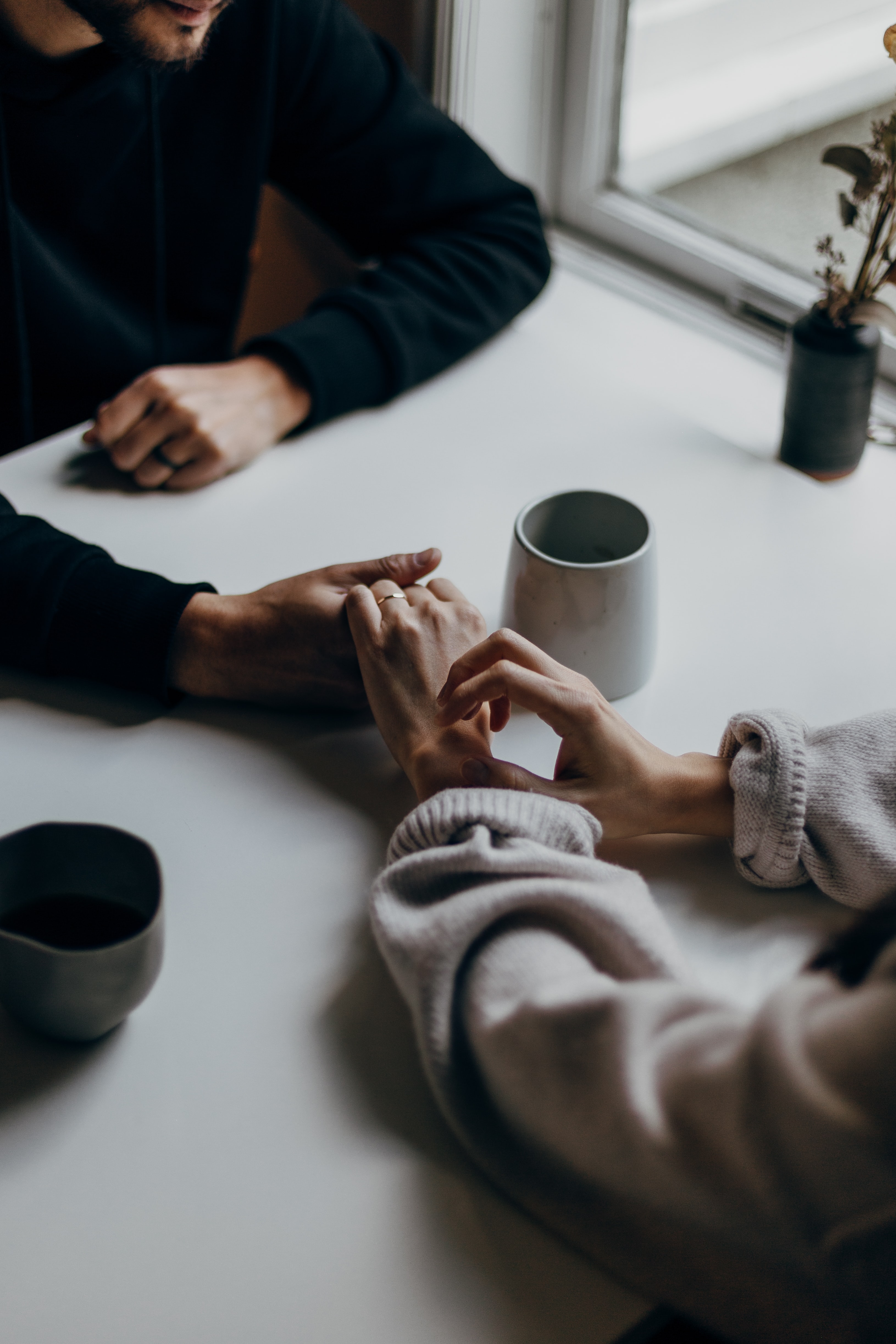 married couple holding hands across a table