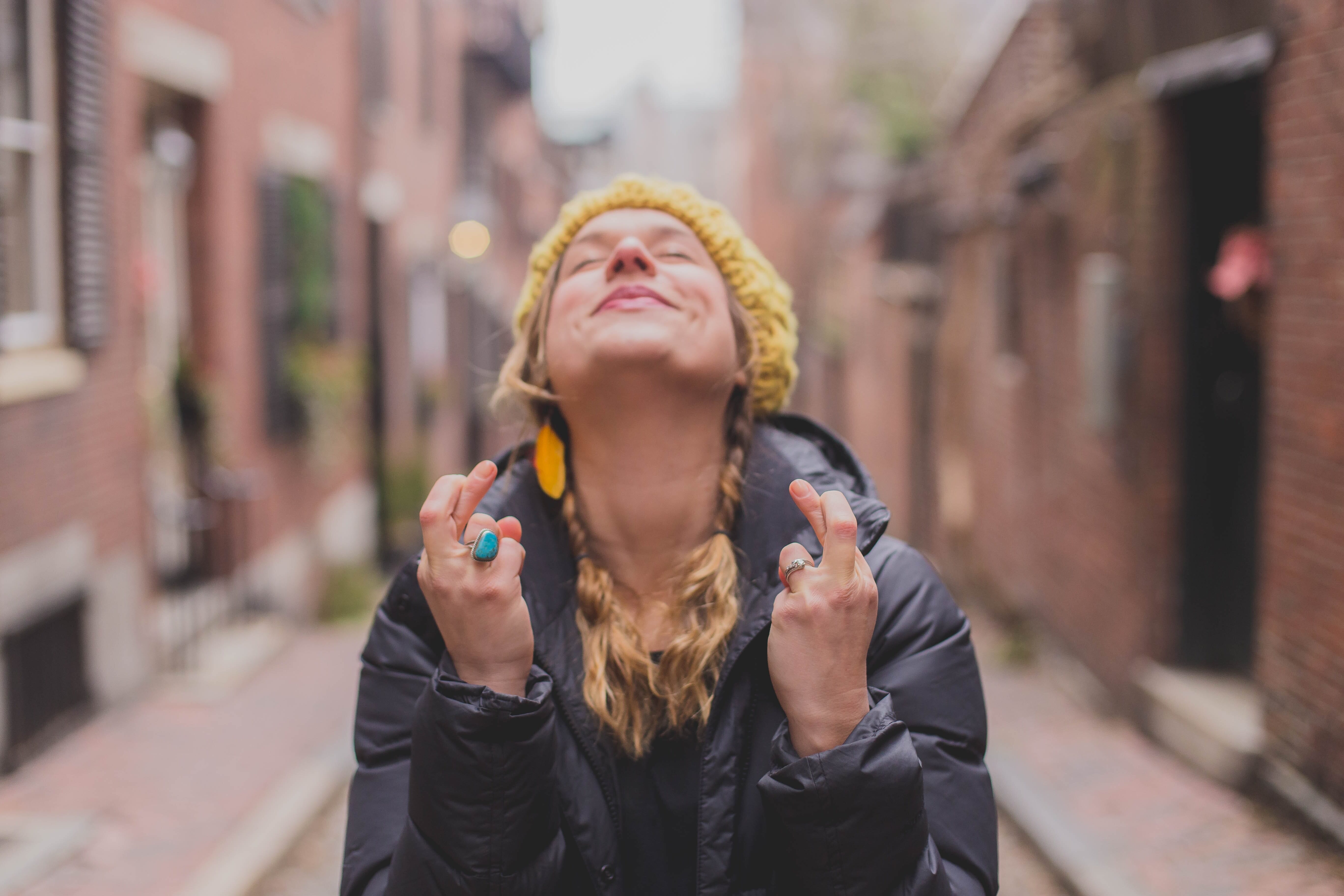 woman looking to the sky and crossing her fingers