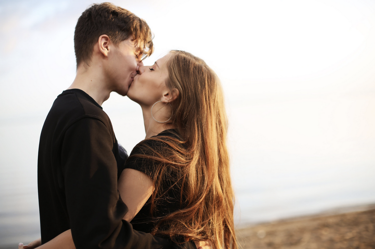 man and woman kissing outdoors