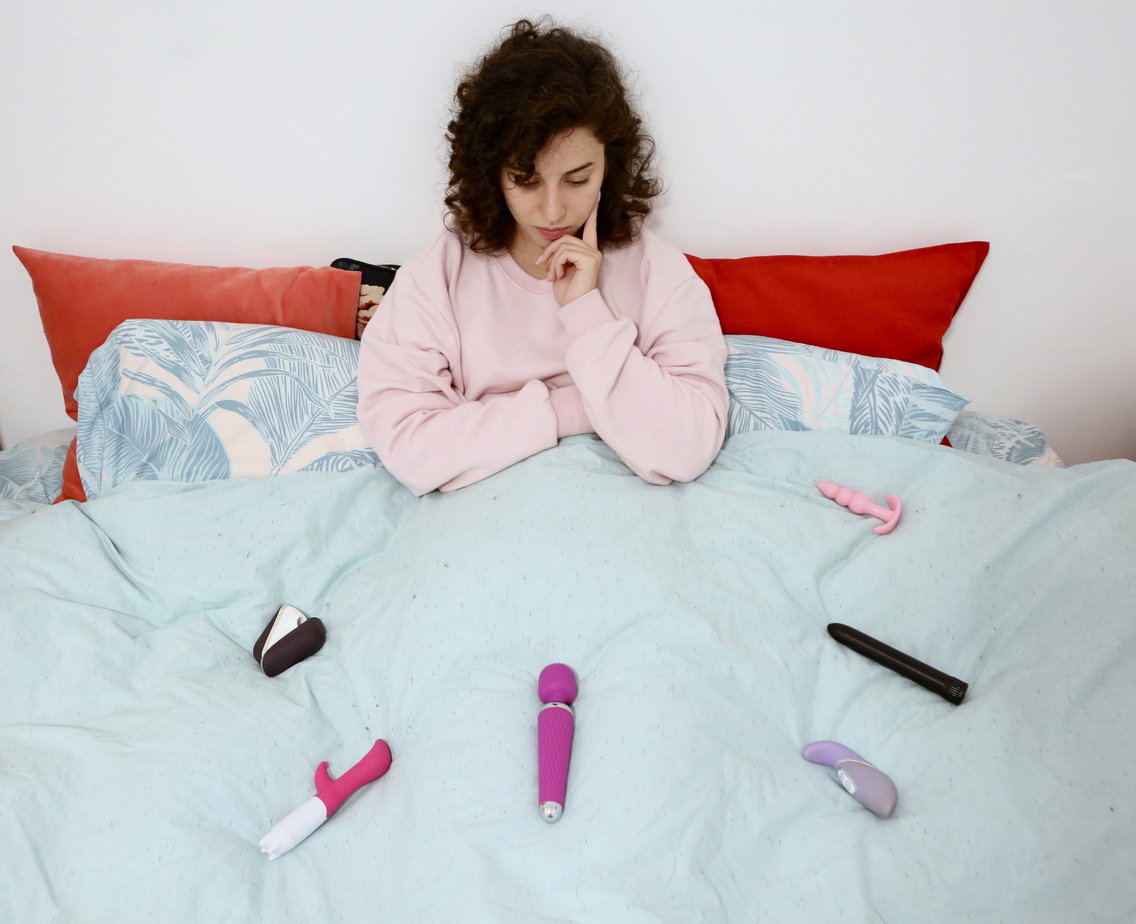 woman deciding between six vibrators