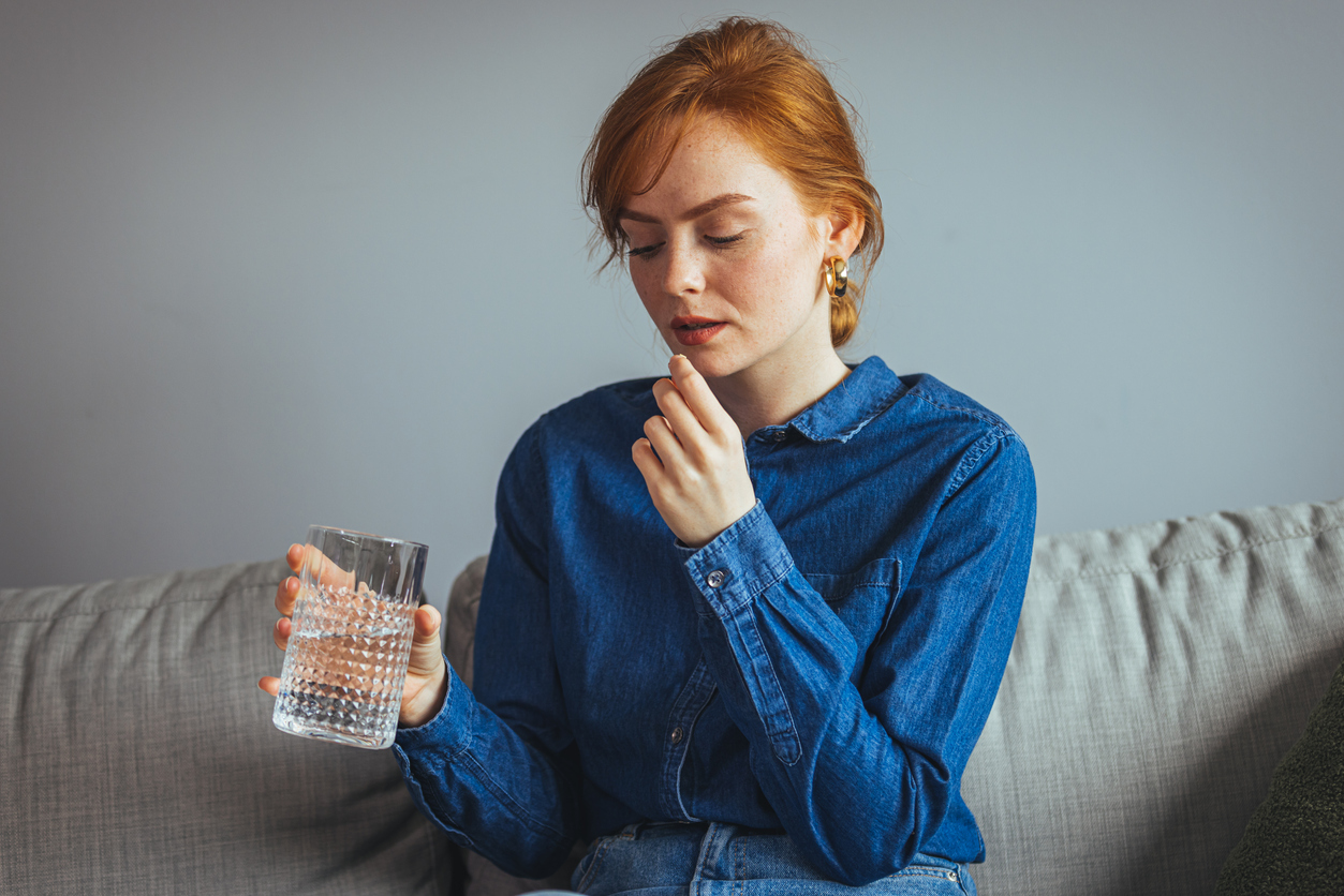 woman taking medication for adult acne