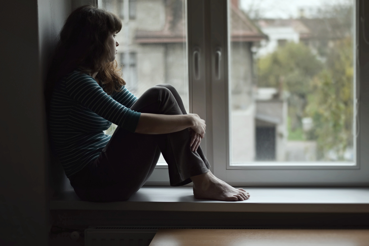 forlorn woman staring out a window