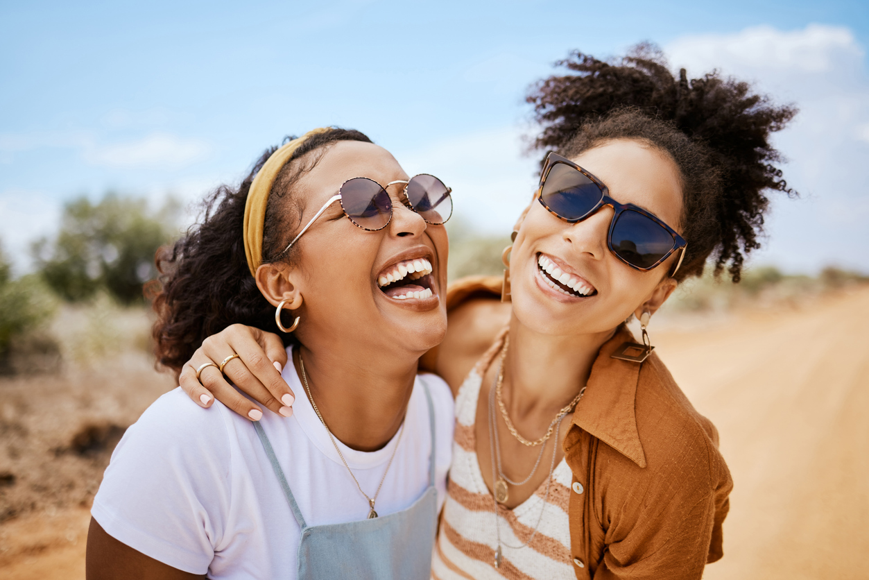 two friends laughing on a dirt road