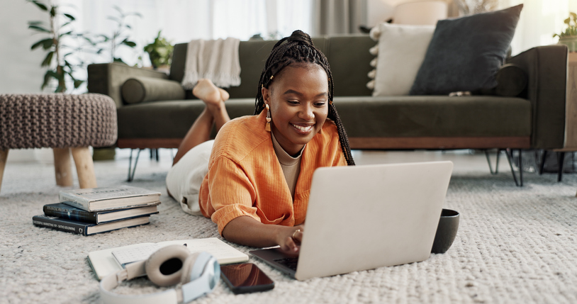 woman lying on the floor looking at her laptop