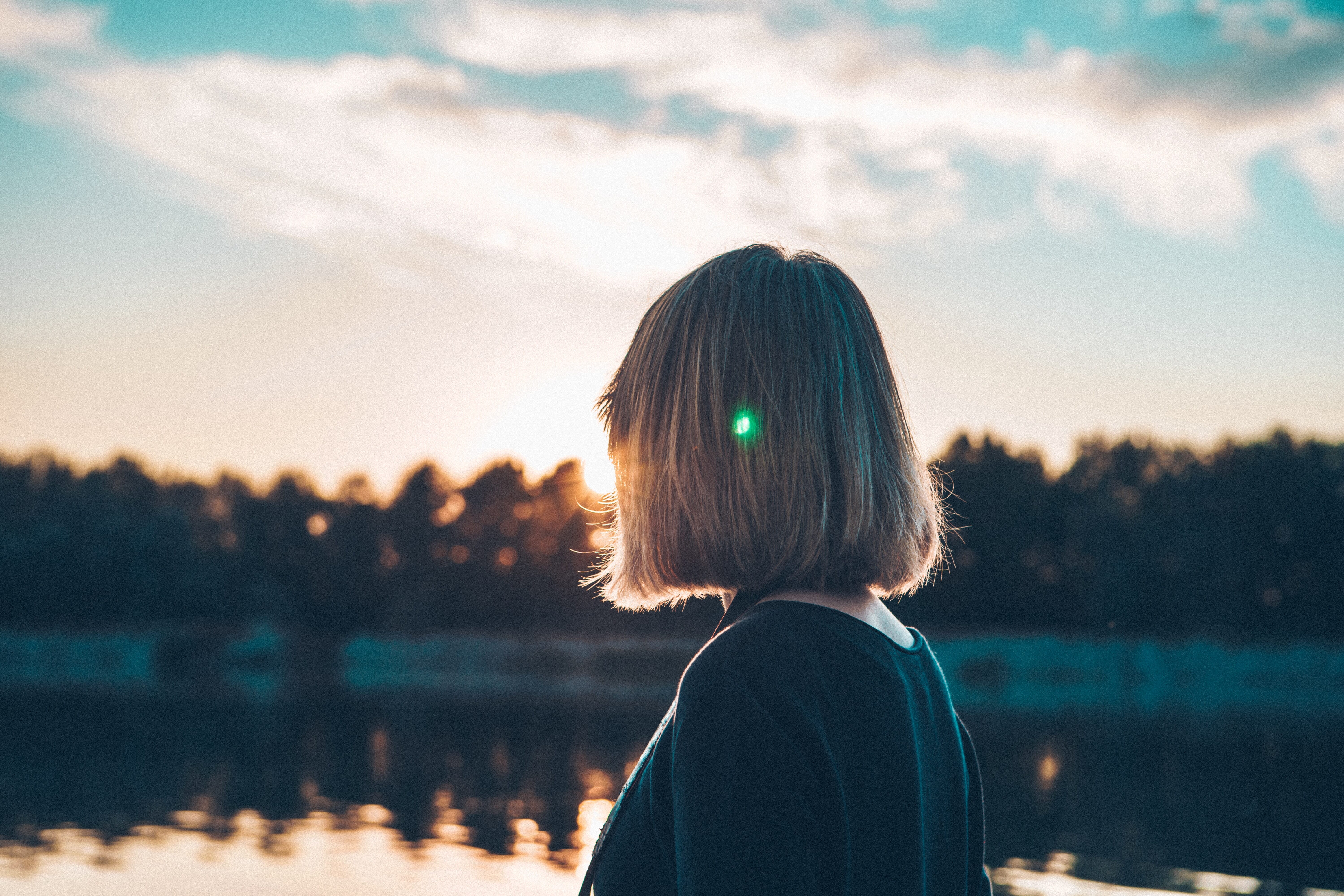 woman with unexplained infertility watching the sunrise over a lake