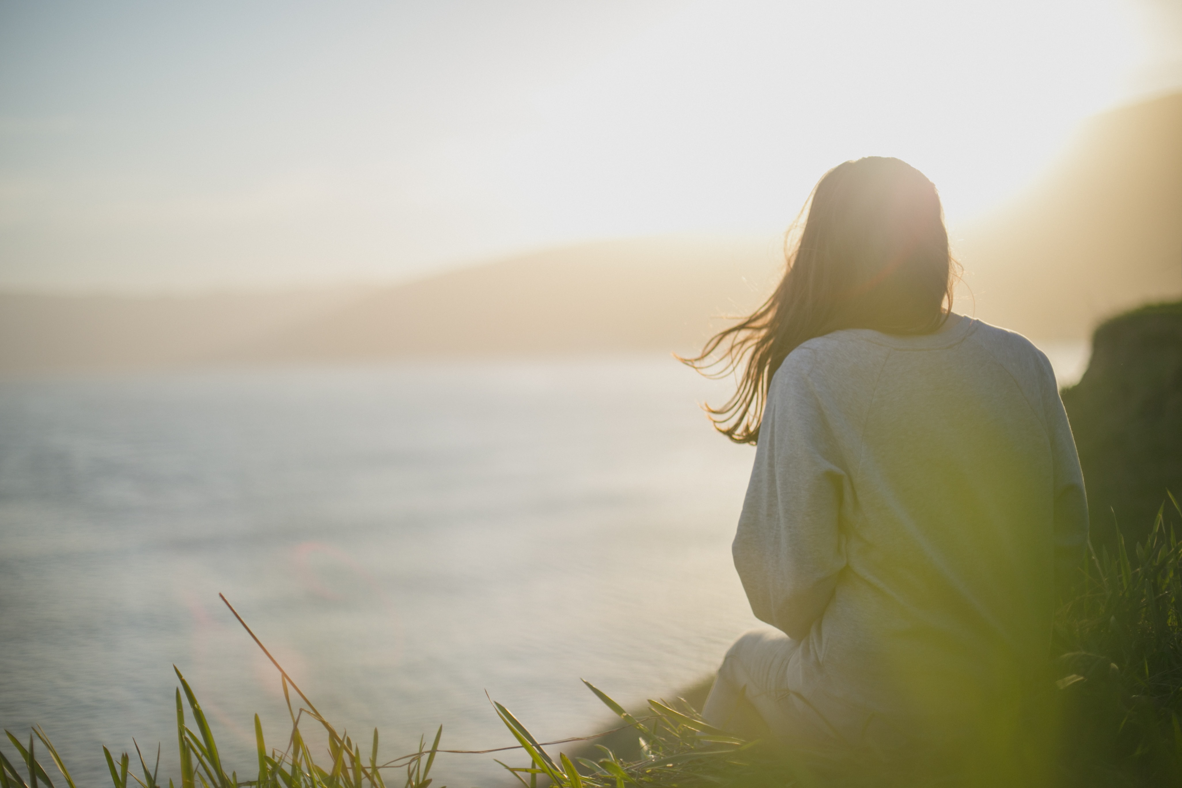 woman watching the sun set over the ocean