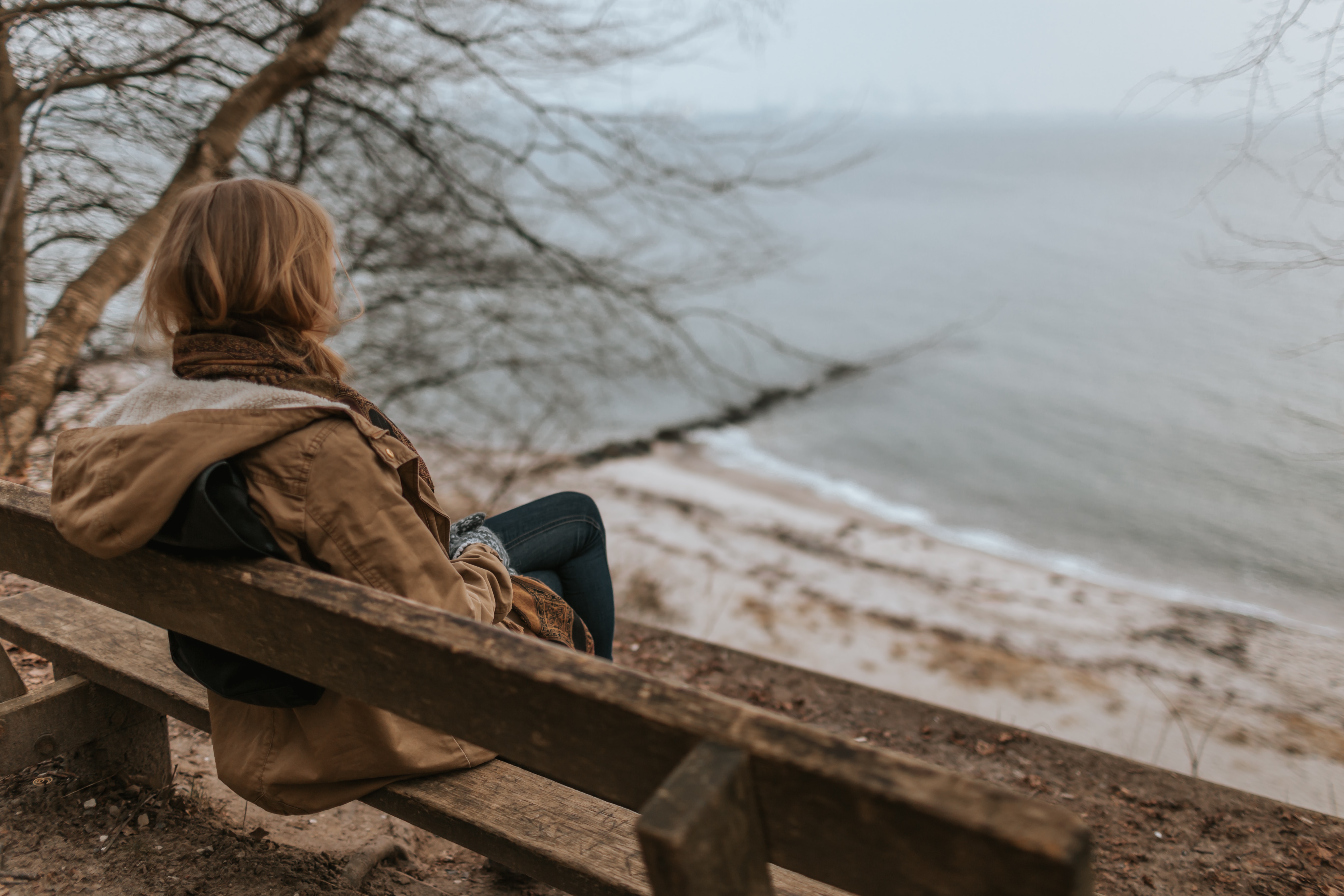 woman sitting on a bench looking at the sea