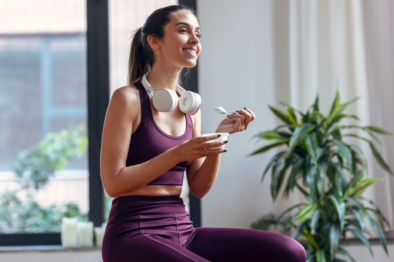 woman eating greek yogurt after a workout