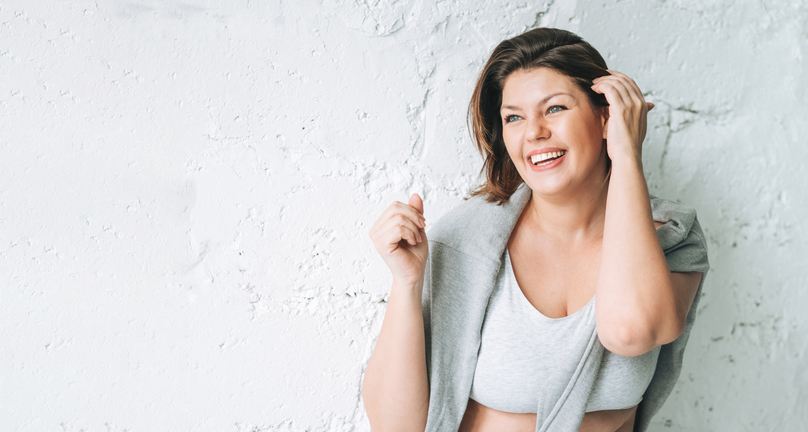 woman smiling against a wall