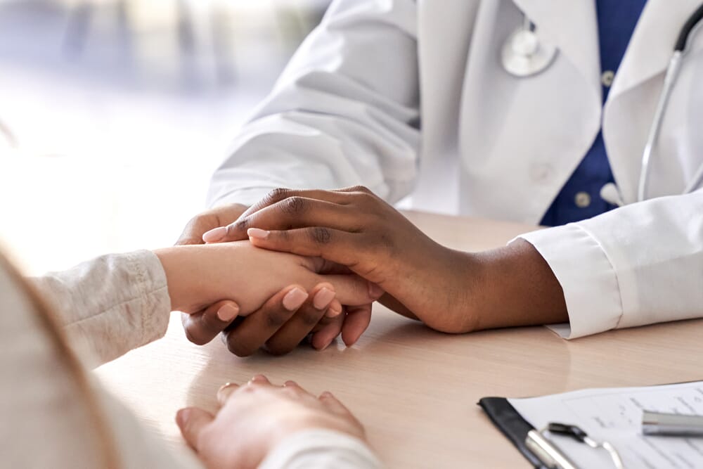 fertility doctor holding patient's hand