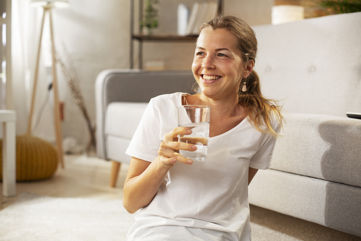 woman smiling and drinking water