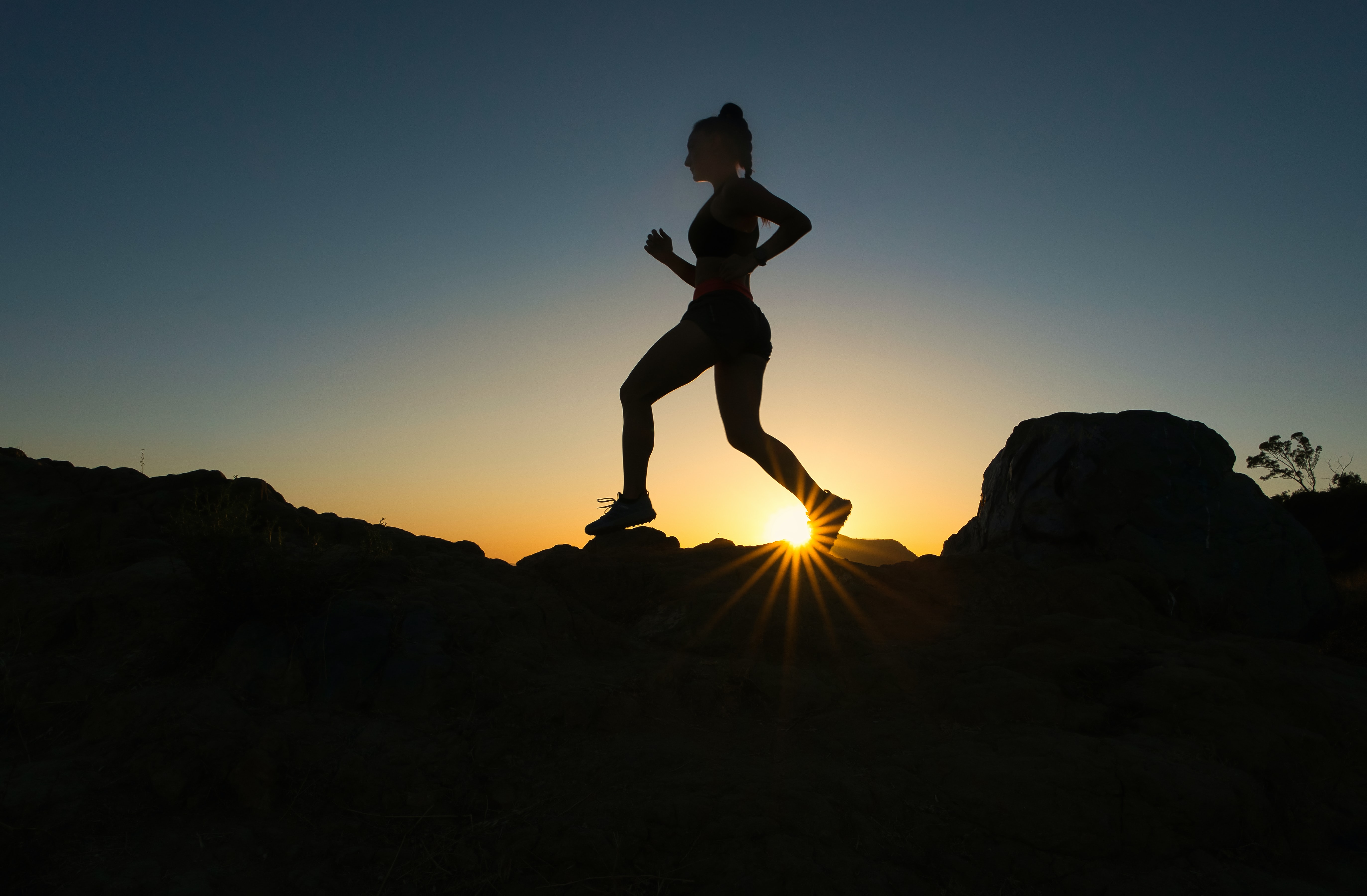 mountain runner in shadow as the sun sets