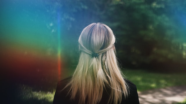 woman bathed in light from a rainbow