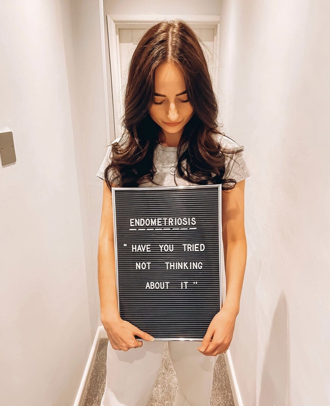 uk ambassador for endometriosis miranda burns holding sign that reads "endometriosis" have you tried not thinking about it"