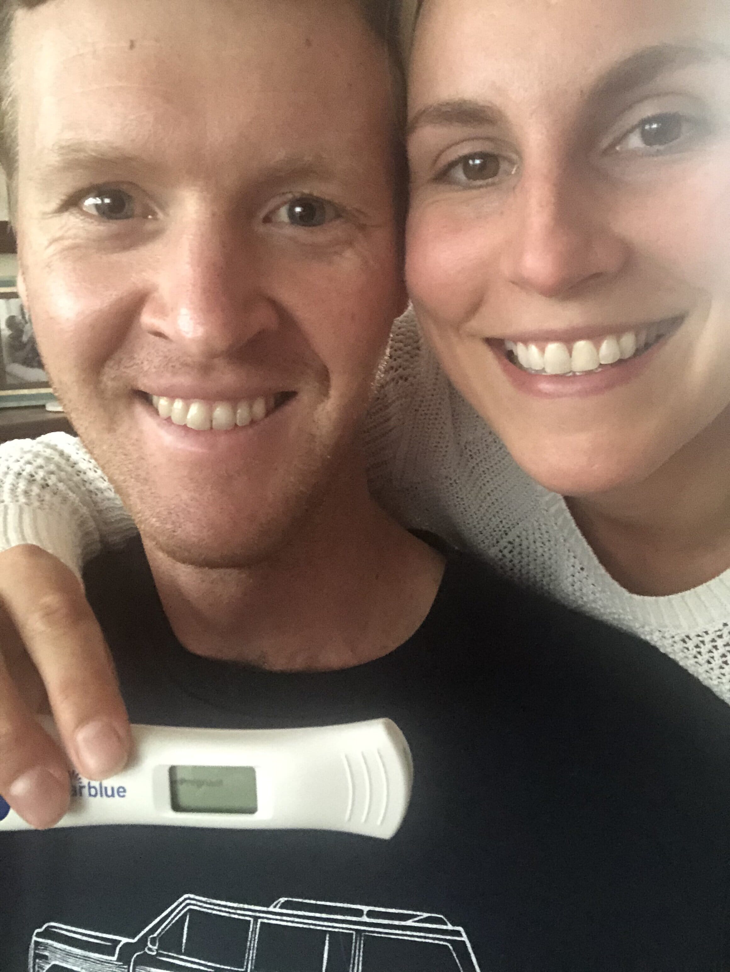 registered nurse suzie welsh and her husband holding a positive pregnancy test