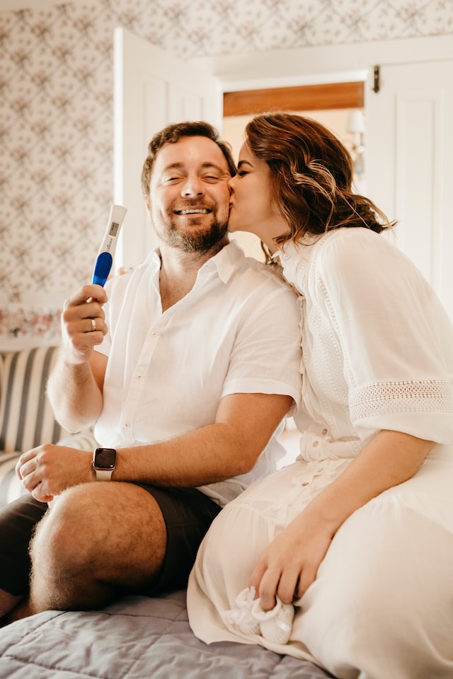 happy couple holding positive pregnancy test