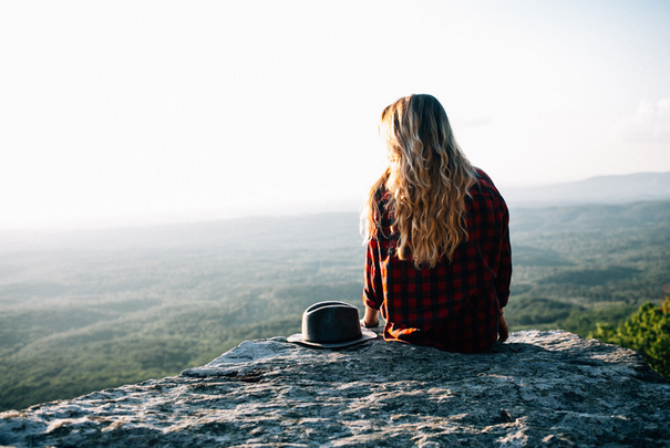 woman sitting on a rock during a hike