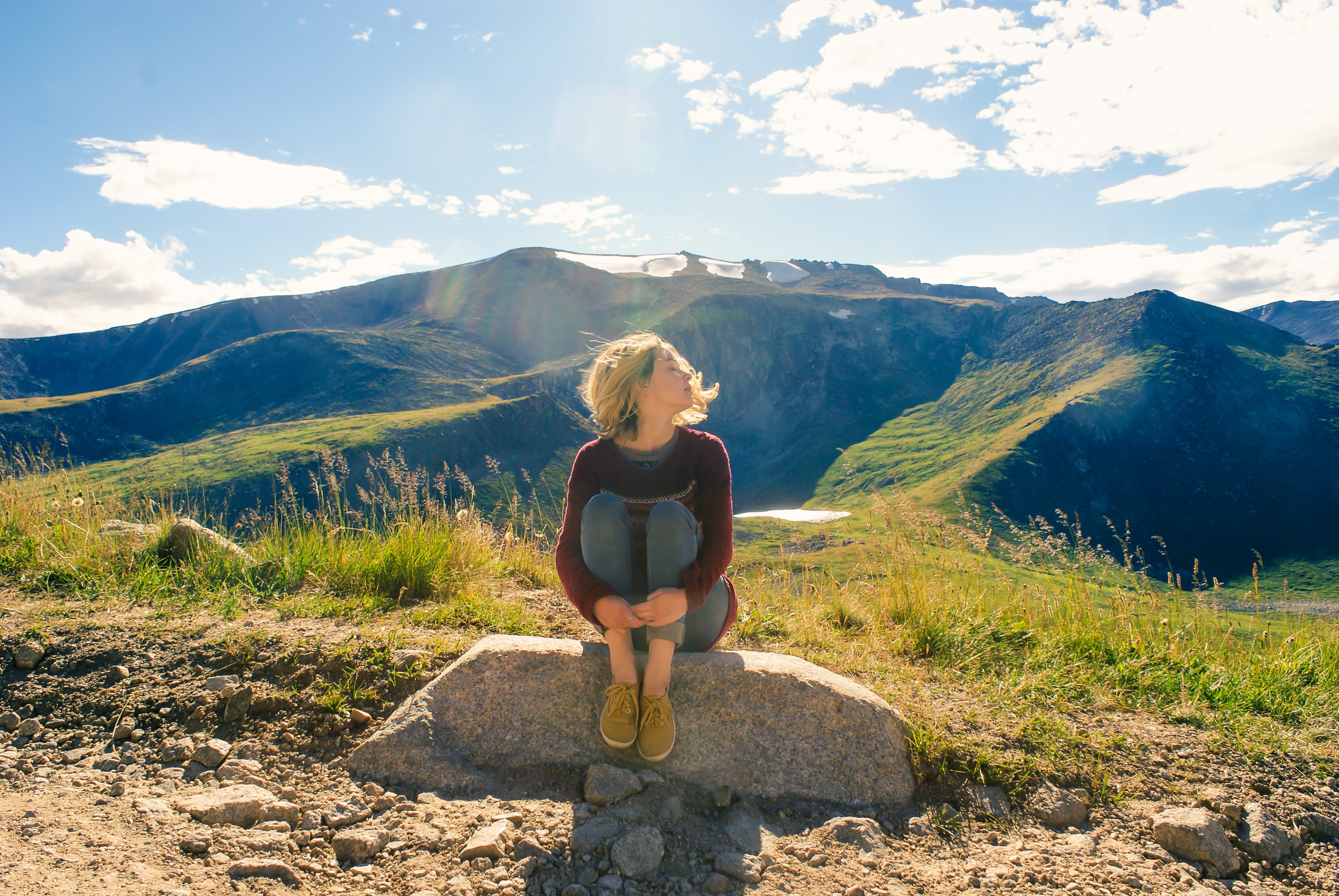 woman sitting on a rock during a hike