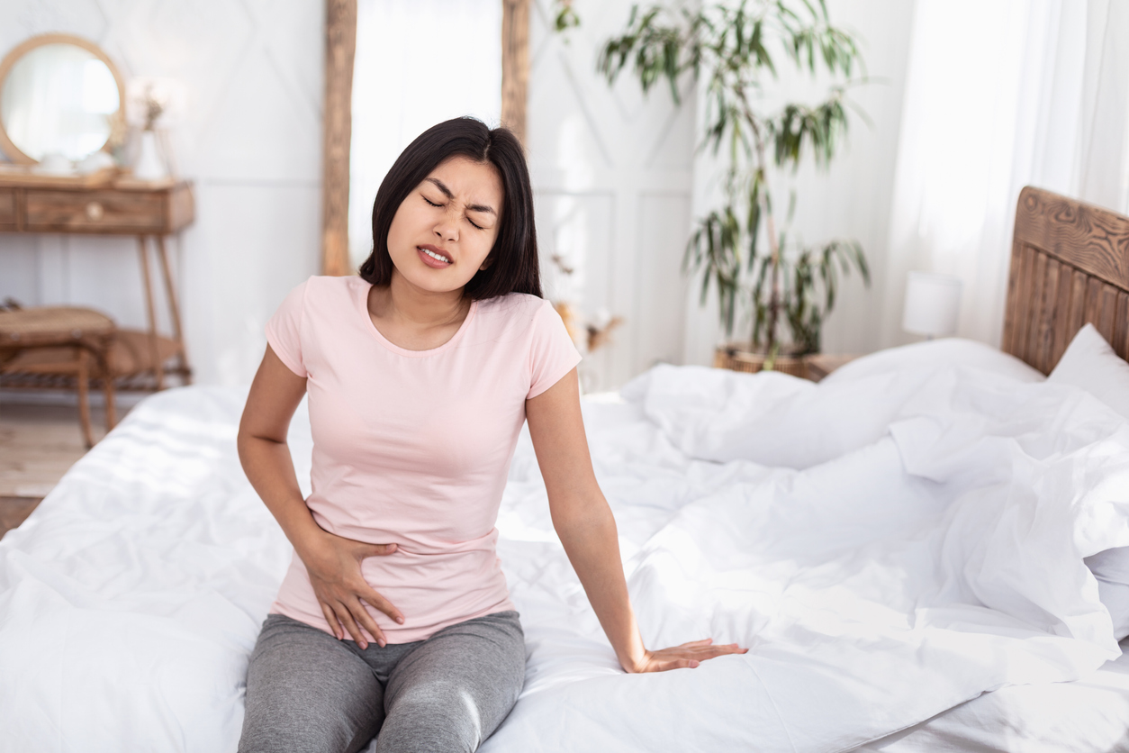 woman gripping her lower abdomen in pain