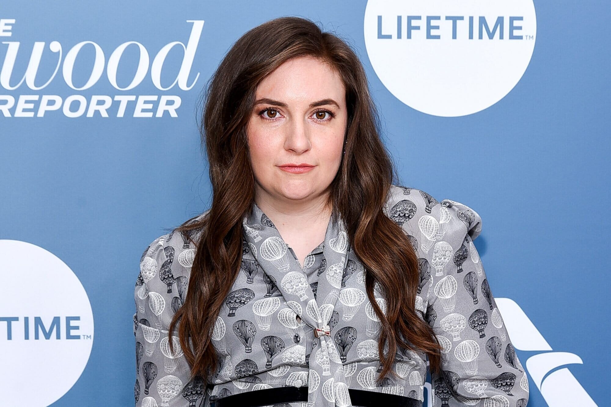 lena dunham posing in silky grey dress