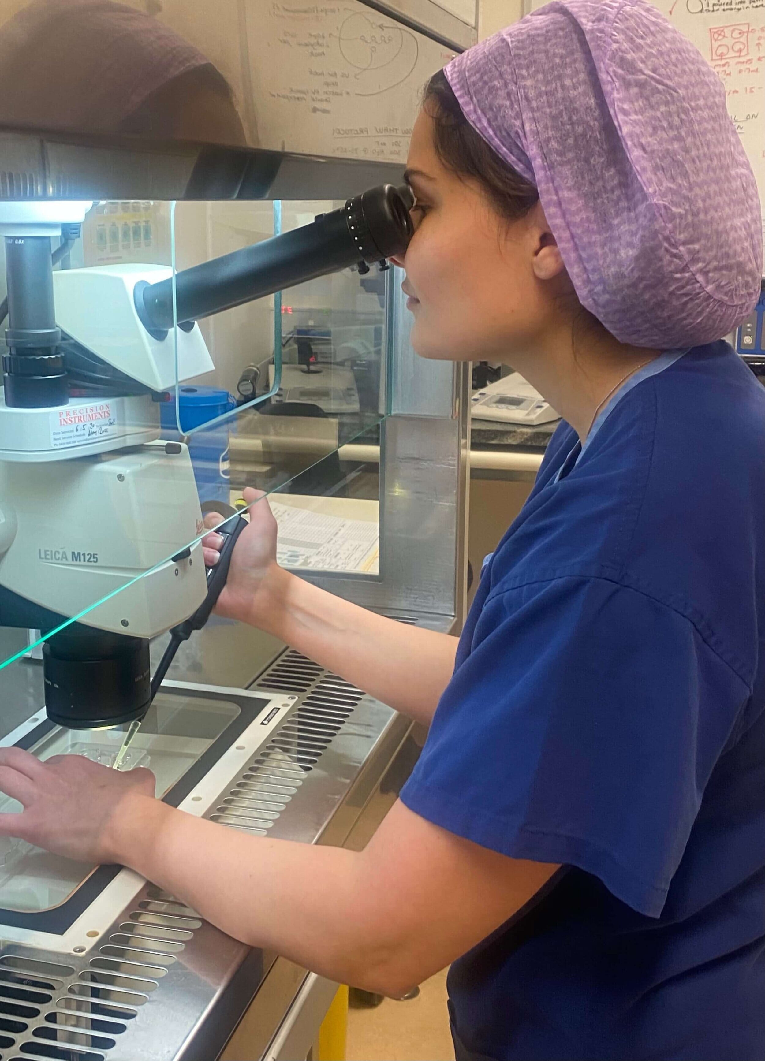 embryologist kristen jones looking in a stereo microscope